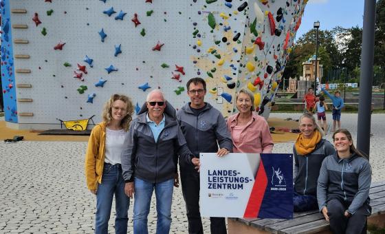 Menschen vor einem Kletterturm