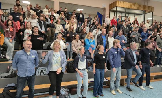 Menschen bewegen sich auf voller Tribüne
