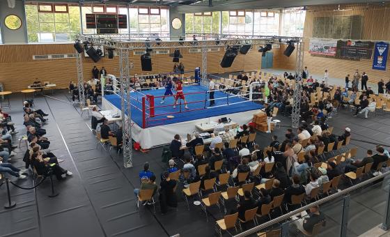 Aufnahmen von oben: Halle mit Boxring und Zuschauern