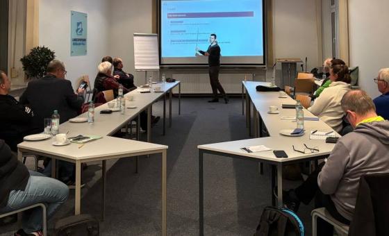 Tagungsteilnehmer an Tischen sitzend