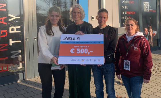 Vier Personen bei Scheckübergabe