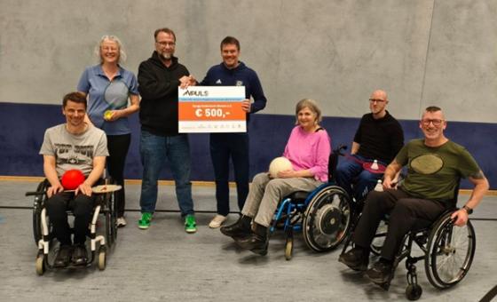 Scheckübergabe in Sporthalle mit Rollstuhlfahrern