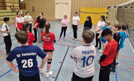 Schüler in Sporthalle bei Volleyball-Einheit