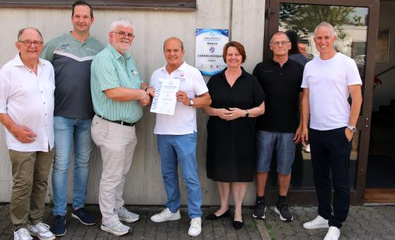 Menschen bei Übergabe von Urkunde