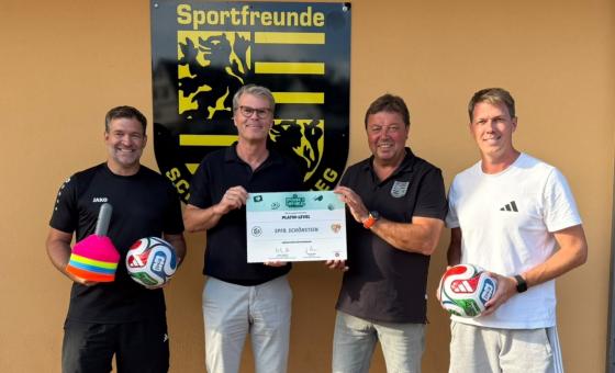 Vier Fußballfunktionäre mit Urkunde
